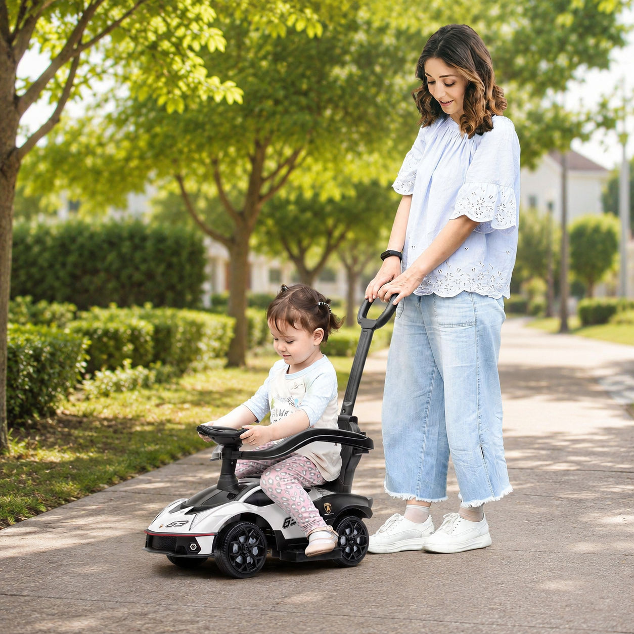 Parent supervising toddler in white Lamborghini push car