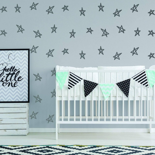Baby crib with decorative flags against a wall with star patterns