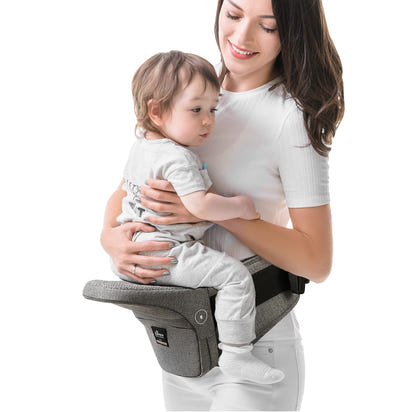 Woman holding a baby in a gray baby carrier against a white background