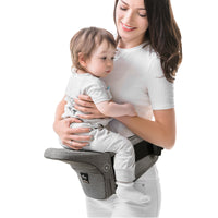 Woman holding a baby in a gray baby carrier against a white background