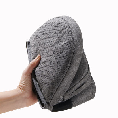 Gray textured cushion held by a hand on a white background