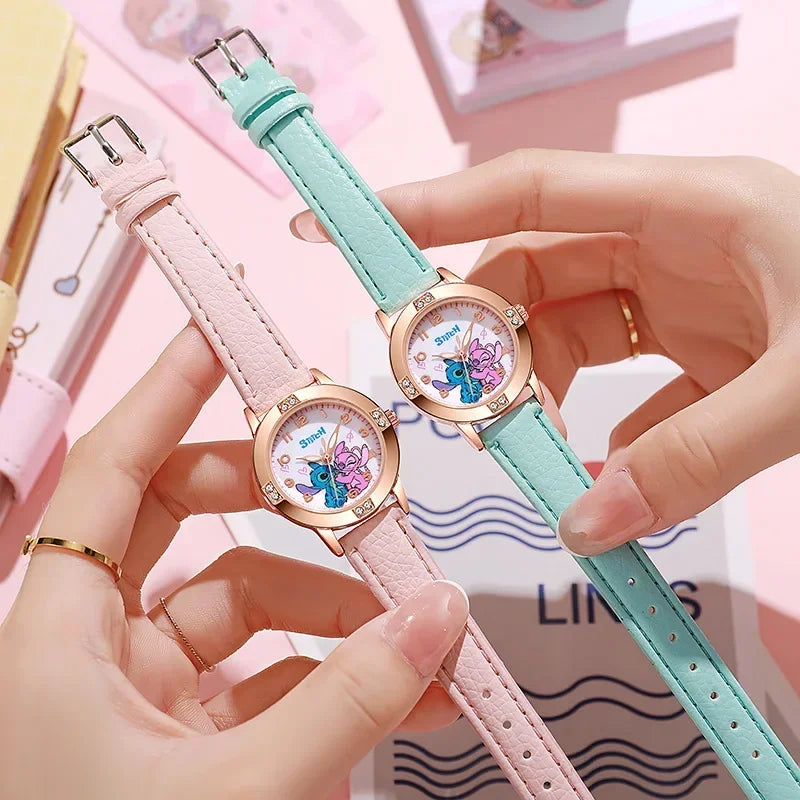 Two cartoon-themed watches with pink and light blue straps held by hands against a blurred background.