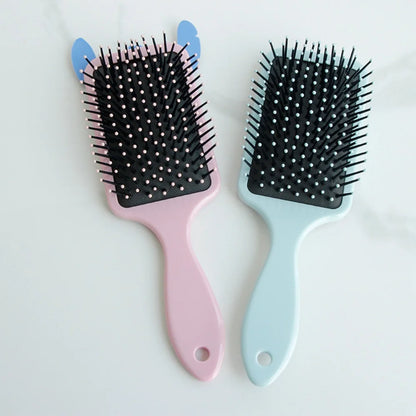 Two hairbrushes, one pink and one blue, with black bristle heads on a white background.