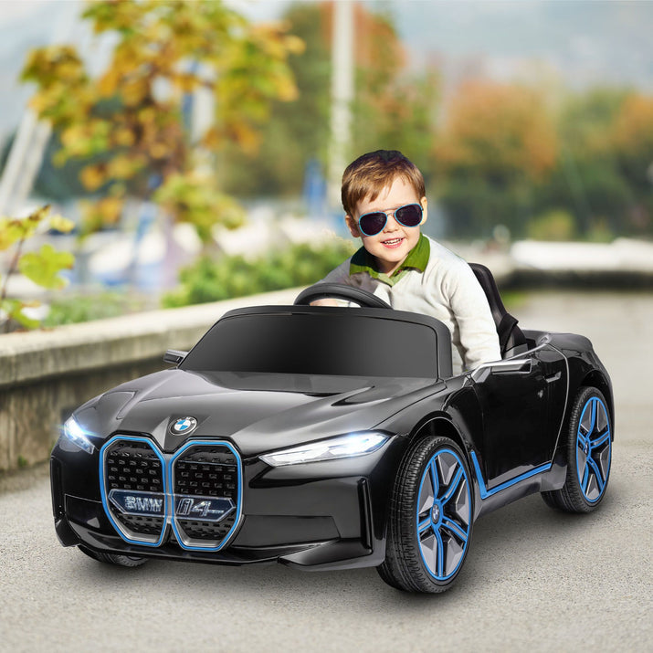 Child driving a toy BMW car on a road with a blurred background