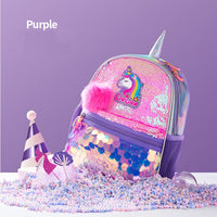 Purple unicorn-themed backpack with sequins and a pink pom-pom on a purple background.