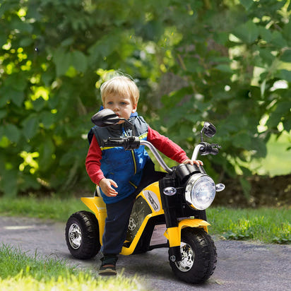 Child playing with a toy motorcycle outdoors
