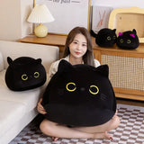 Person holding a large round black cat plush pillow